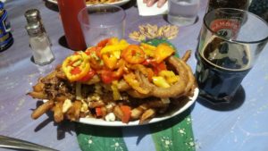 a plate of poutine with hot peppers