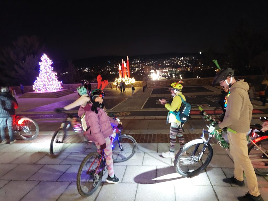 bicycle riders on plaza with Christmasdecorations